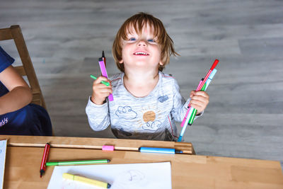 Little boy drawing with felt-tip pens