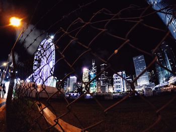 Illuminated ferris wheel against sky at night