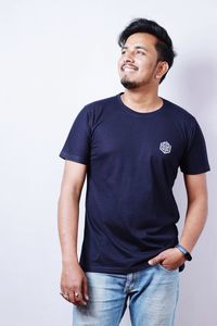 Portrait of young man standing against white background