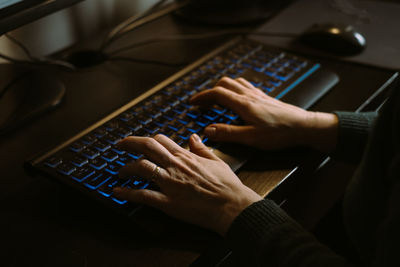 Woman hands working on keyboard. evening light. freelancer doing her work at home. it specialist