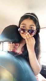 Portrait of young woman sitting in sunglasses