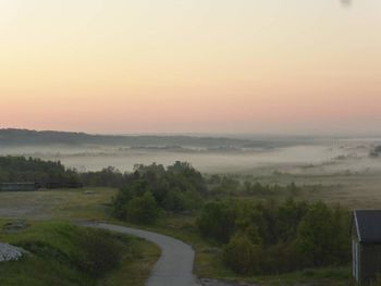 Scenic view of agricultural landscape against sky during sunset