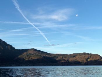 Scenic view of lake and mountains against blue sky