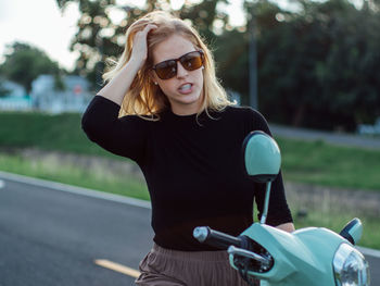 Portrait of young woman wearing sunglasses while standing outdoors