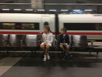 Full length of woman sitting at subway station
