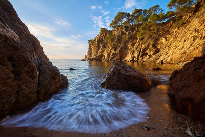 Scenic view of rocks in sea against sky