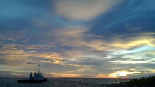 View of boats in sea at sunset