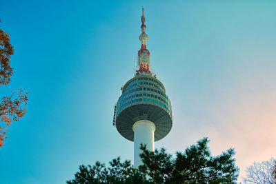 Low angle view of communications tower and buildings against sky