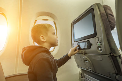 Rear view of boy using mobile phone