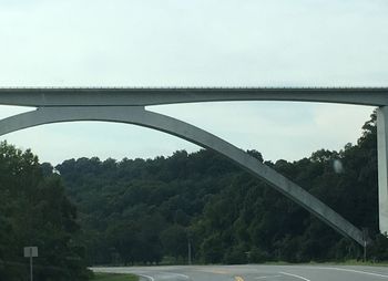 Bridge over river in city against clear sky