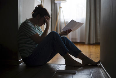 Side view of young woman reading book