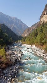 Scenic view of river amidst mountains against clear sky