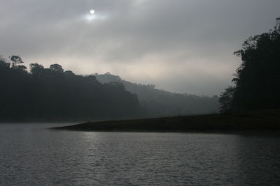 Scenic view of lake by trees against sky