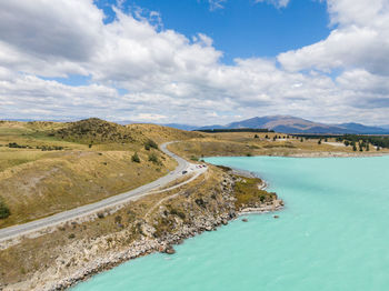 Drone view of state highway 8 along lake pukaki, an alpine lake on new zealand's south island.