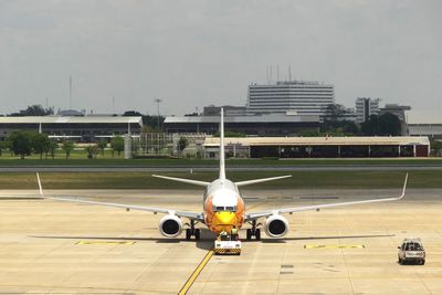 Airplane on runway against sky