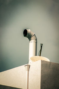 Low angle view of electric lamp against wall