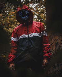 Man with umbrella standing in forest