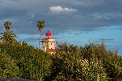 Lighthouse by sea against sky