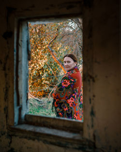 Portrait of cute girl looking through window