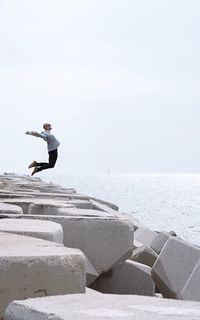 Side view of man jumping on beach