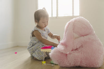 Girl looking away while sitting on floor at home