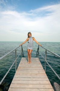 Woman standing on railing against sea