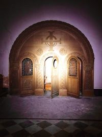 Illuminated entrance of historic building at night