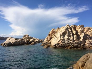 Rock formations by sea against sky