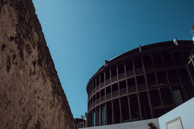Low angle view of buildings against clear blue sky