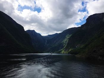 Scenic view of lake by mountains against sky