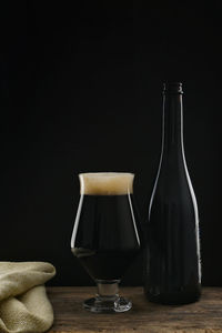 Bottle an glass of craft dark stout beer with chocolate flavor