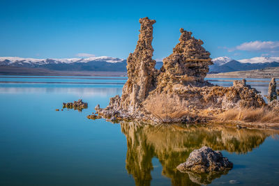 Scenic view of lake by mountain against sky