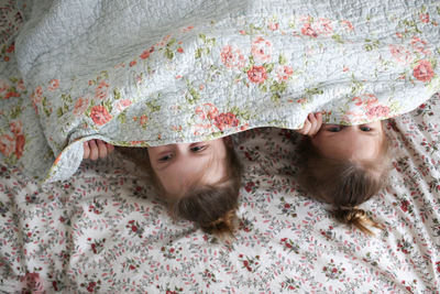 Sister's girls play and cuddle under a blanket, emotions. 