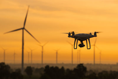 Silhouette helicopter against sky during sunset