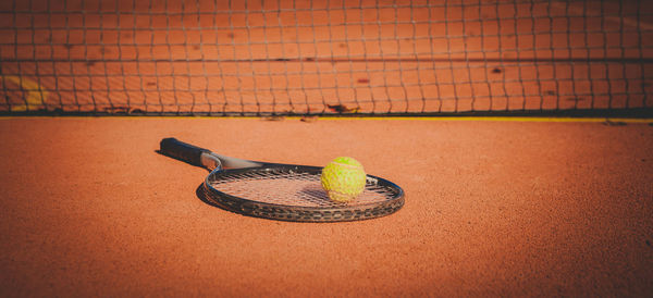 Close-up of tennis ball and racket on court