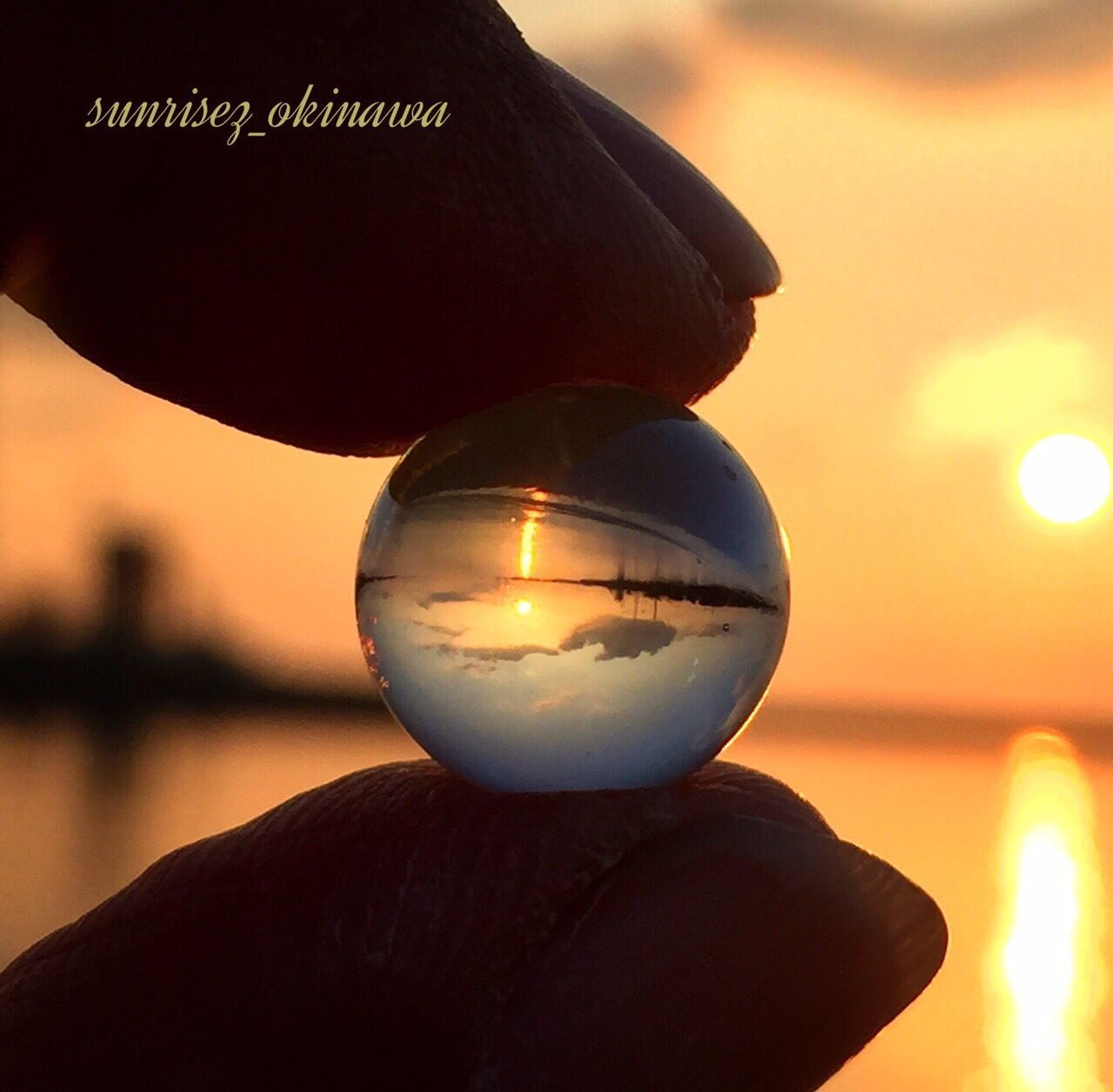 illuminated, focus on foreground, sunset, close-up, sun, lighting equipment, sphere, lens flare, light bulb, orange color, glowing, sky, holding, night, dusk, reflection, outdoors, flame