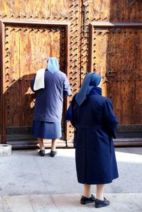 Rear view of nuns against old door