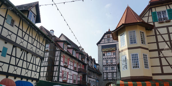 Low angle view of buildings in town against sky