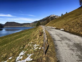 Road leading towards mountains against sky