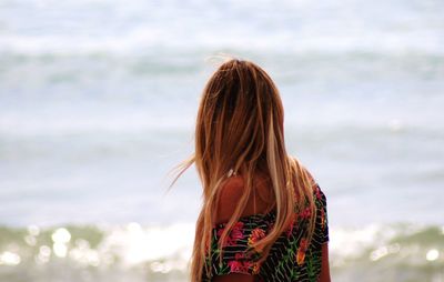 Rear view of woman standing against sea
