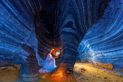 Full length of woman in illuminated cave