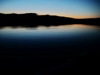 Scenic view of lake against sky at sunset