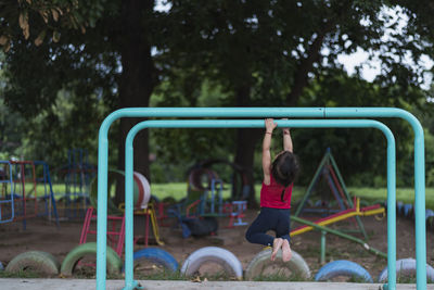 Rear view of woman exercising in playground