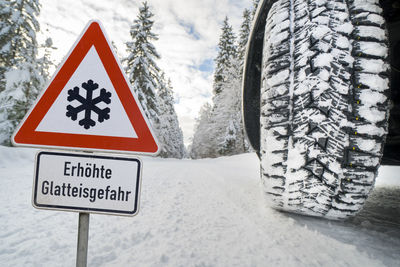 Road sign warns of ice and snow at winter