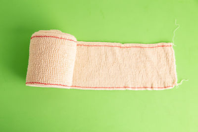 Close-up of rolled bandage over colored background