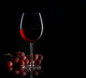 Red wine glass against black background