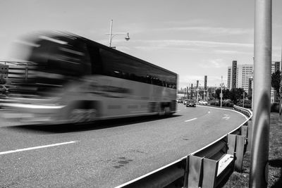 Blurred motion of cars on road in city against sky