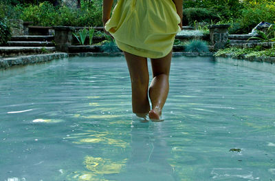 Low section of woman standing in water