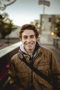 Portrait of smiling man standing on footbridge