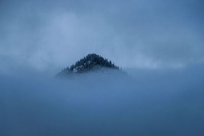 Scenic view of mountain covered by clouds against sky